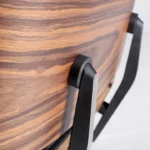 Close-up of welted brown leather cushion beside rosewood veneer grain